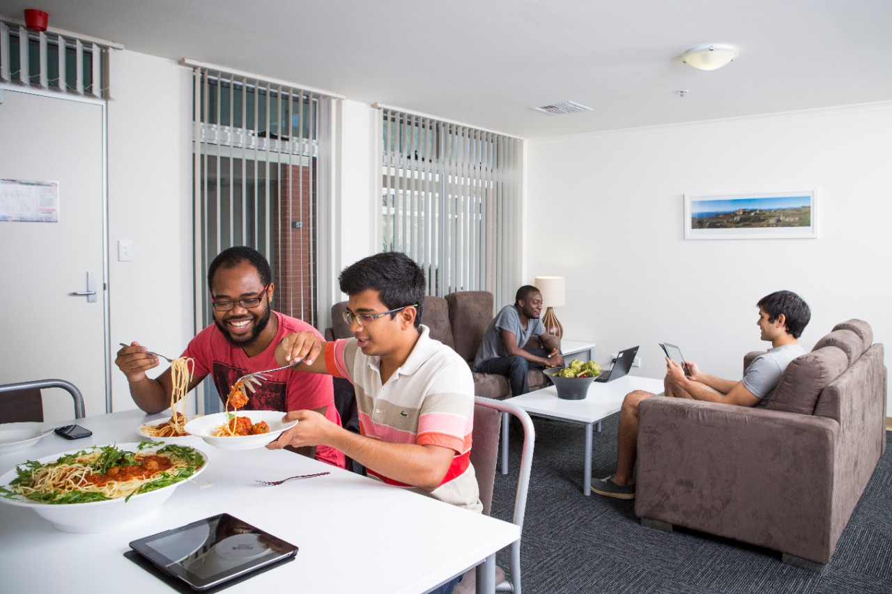 Students eating in the dining room of an apartment at the The Village student accommodation complex